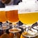 A flight of 4 different beers and tasting glasses on a table